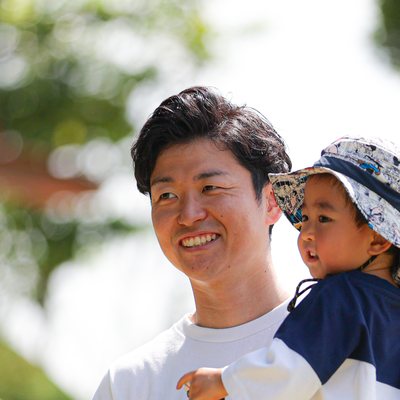 お子さんを抱いて笑顔の金子大志